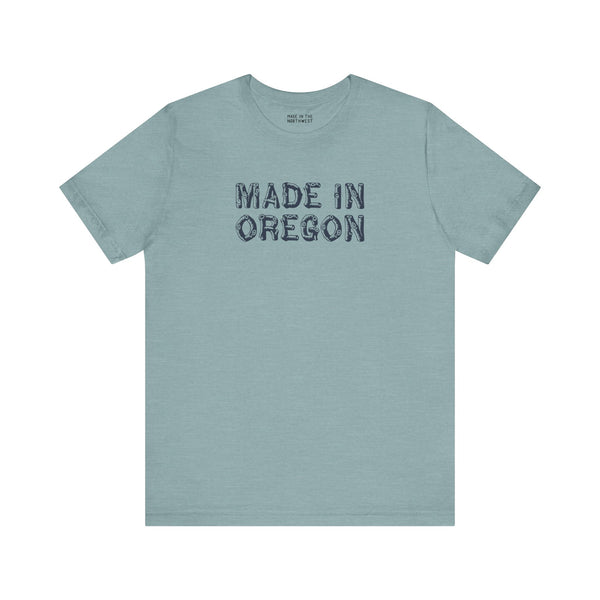 Premium soft tee featuring rustic 'Made in Oregon' log font on a blue-green background, perfect for outdoor enthusiasts.