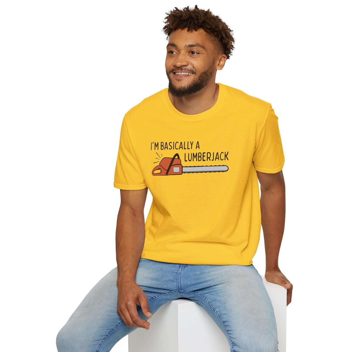 Man wearing a yellow Basically a Lumberjack T Shirt with chainsaw graphic, showcasing rugged outdoor style.