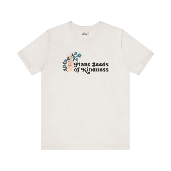 Plant Seeds of Kindness premium soft tee featuring a peace sign and blooming flowers, promoting love and positivity.
