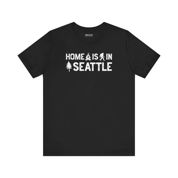Home Is in Seattle Tee featuring Bigfoot and pine tree designs, celebrating Emerald City pride.