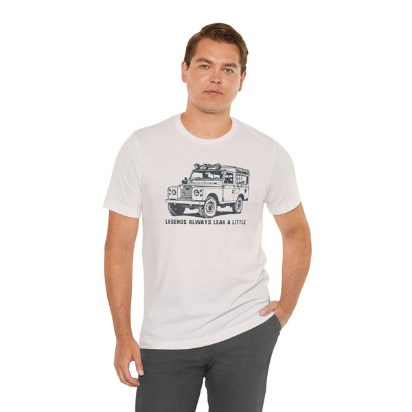 Man wearing 'Legends Always Leak a Little' tee featuring Land Rover Series II graphic, symbol of classic adventure.