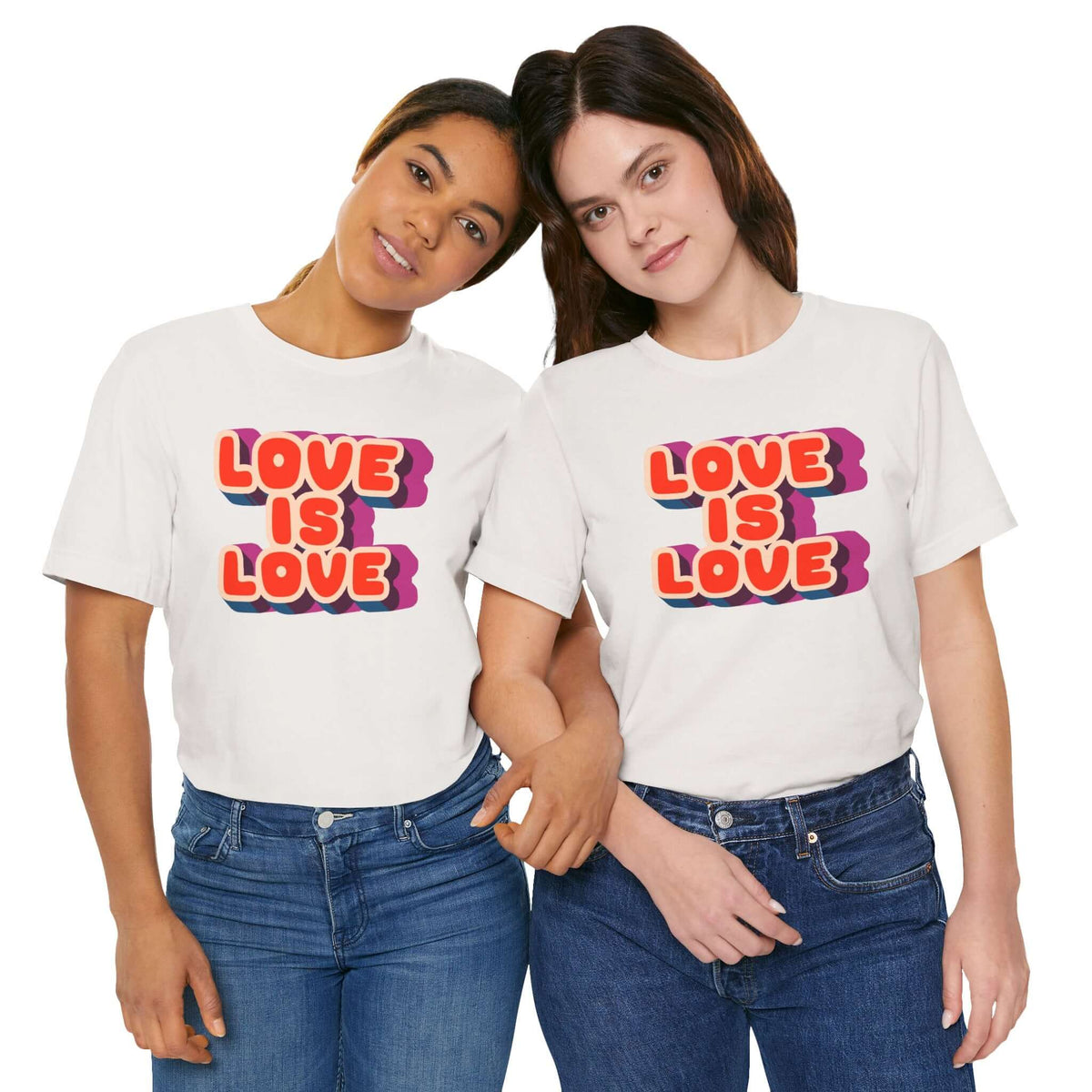 Two women wearing a Love Is Love T shirt with colorful retro letters, promoting pride and positivity.