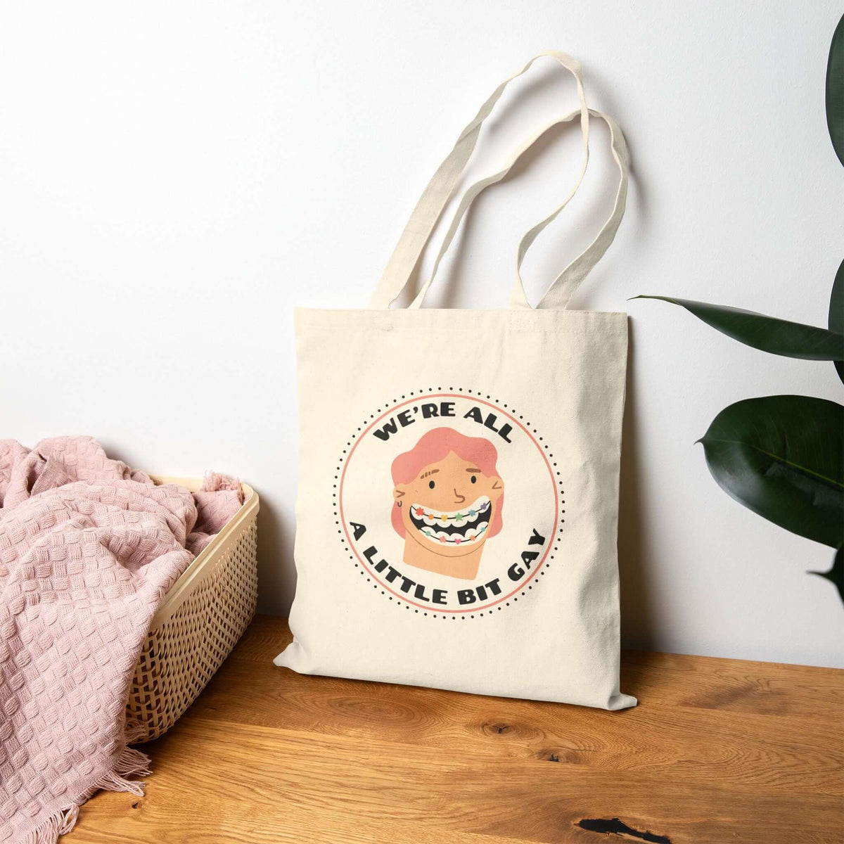 We're All a Little Bit Gay tote bag displayed with a playful design, perfect for expressing pride and joy.