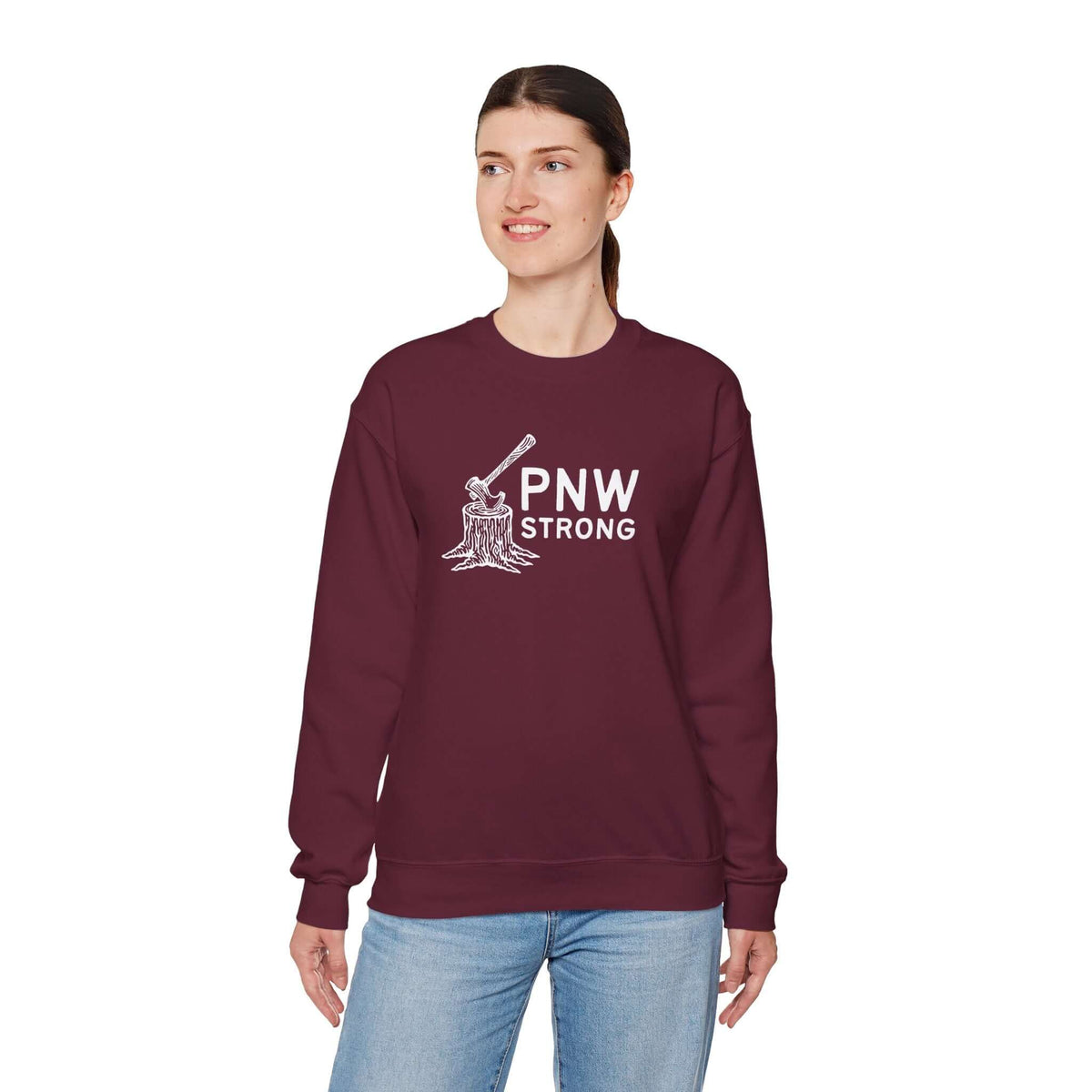 Woman wearing a PNW Strong Crewneck Sweatshirt with axe-in-stump design in burgundy color.