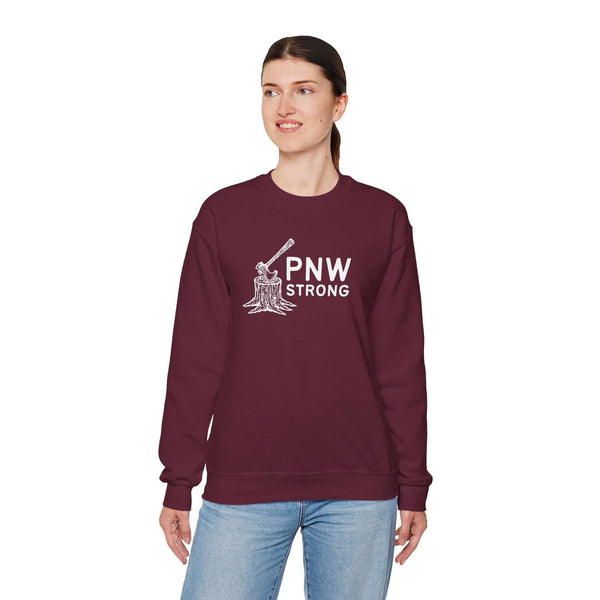 Woman wearing a PNW Strong Crewneck Sweatshirt with axe-in-stump design in burgundy color.