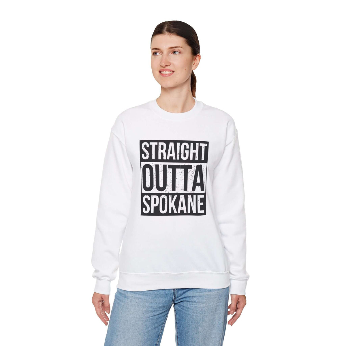 Woman wearing a white "Straight Outta Spokane" sweatshirt showcasing city pride in streetwear style.