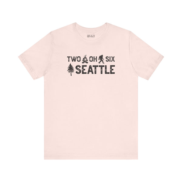 Two Oh Six Roots Premium Soft Tee in light color featuring Seattle area code design with axe and trees.