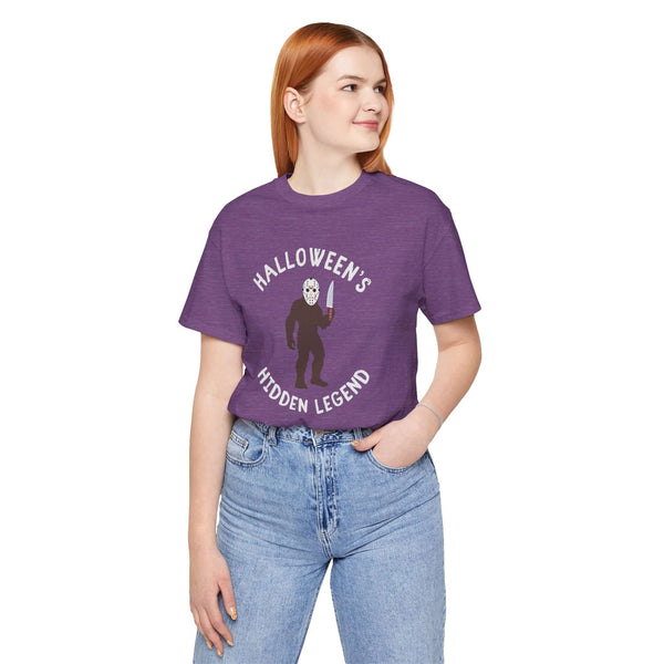 Model wearing Halloween's Hidden Legend Bigfoot tee in purple, featuring Bigfoot in a horror-themed design.