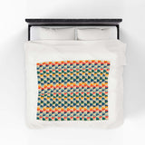 Apres Evergreen in the PNW Retro Lightweight Cozy Blanket showcasing a vibrant geometric pattern on a bed.