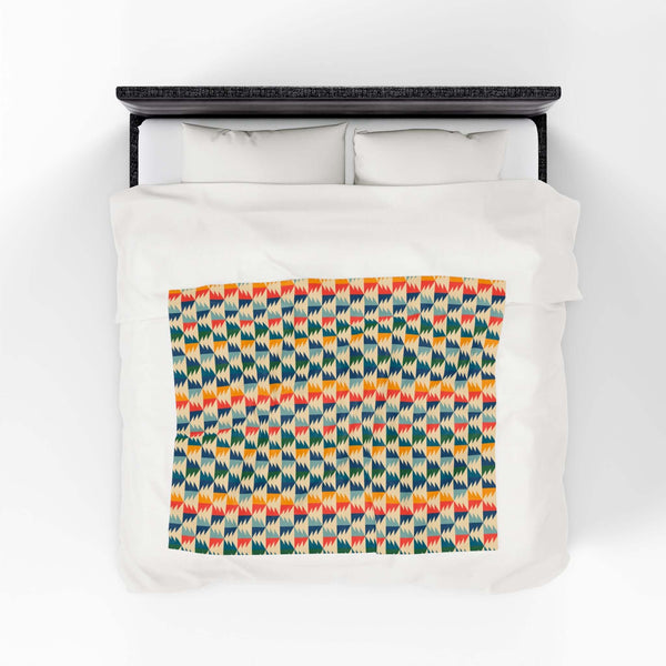 Apres Evergreen in the PNW Retro Lightweight Cozy Blanket showcasing a vibrant geometric pattern on a bed.