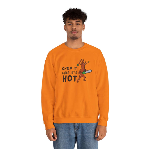 Bright orange unisex crewneck sweatshirt with "Chop It Like It’s Hot" design featuring an animated tree and chainsaw.