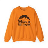 Made in the PNW sweatshirt in vibrant orange featuring a mountain and moon graphic.