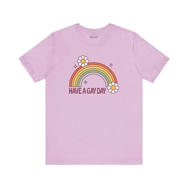 Have a Gay Day T Shirt featuring a rainbow and flowers on a pastel pink background.