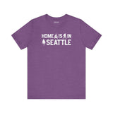 Home Is in Seattle Tee featuring a design with trees and Bigfoot in purple for Emerald City pride.