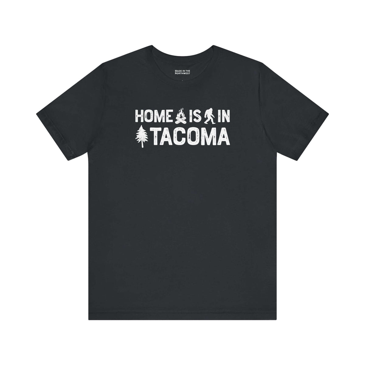 Home is in Tacoma tee featuring campfire, tree, and Bigfoot symbols on a black t-shirt.