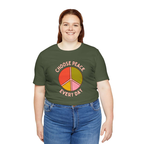 Model wearing Choose Peace Every Day Premium Soft Tee with colorful peace symbol on olive green background.