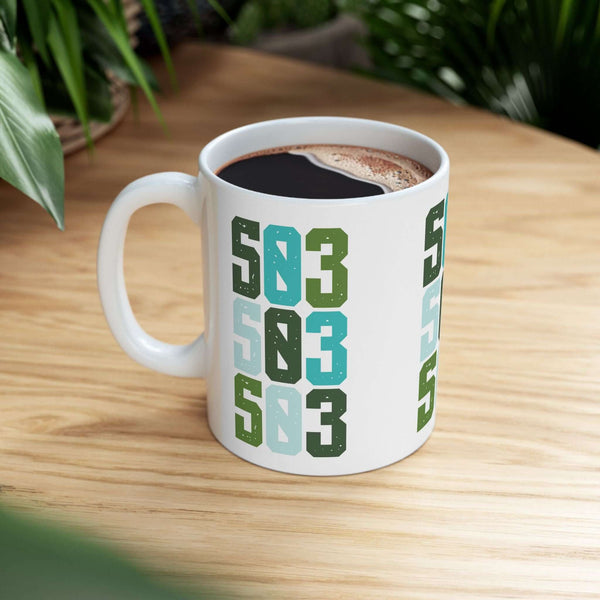 Five-Oh-Three Pop ceramic mug with vibrant stacked design showcasing Portland's 503 area code on a wooden table.
