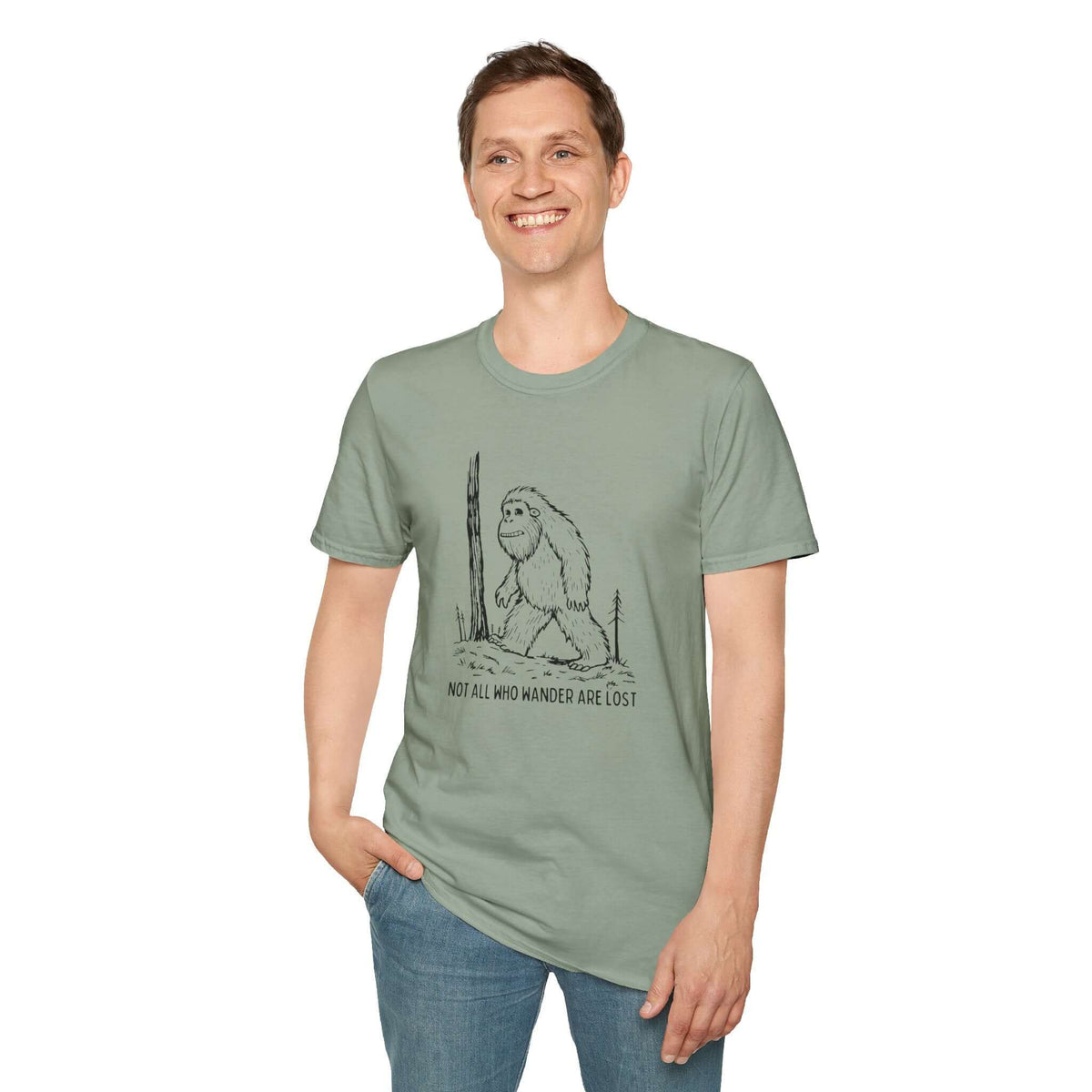 Man wearing Not All Who Wander Are Lost Bigfoot Softstyle T-Shirt in green with Sasquatch design.