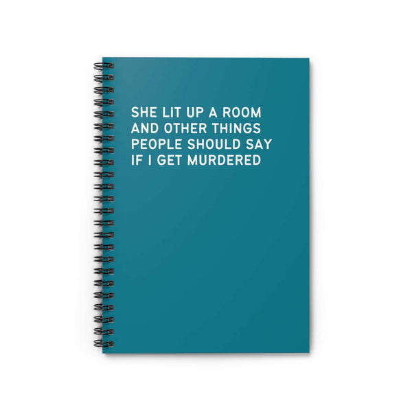 Spiral notebook with teal cover and text: 'She Lit Up a Room and Other Things People Should Say if I Get Murdered'.