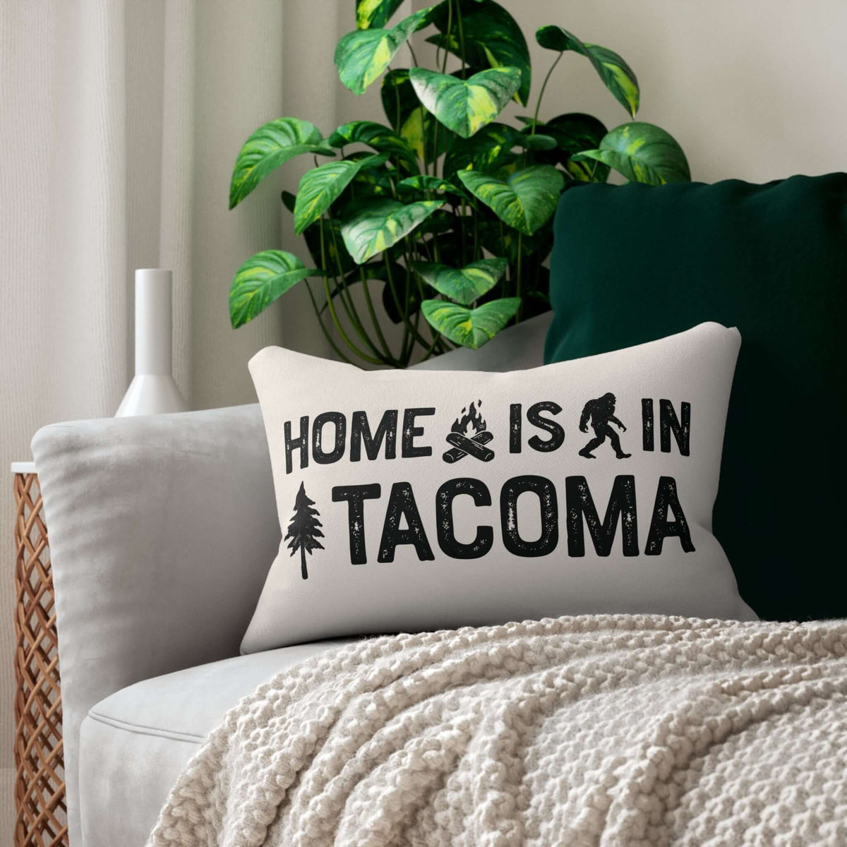 Home is in Tacoma Lumbar Accent Pillow on a sofa with a cozy blanket and indoor plants.