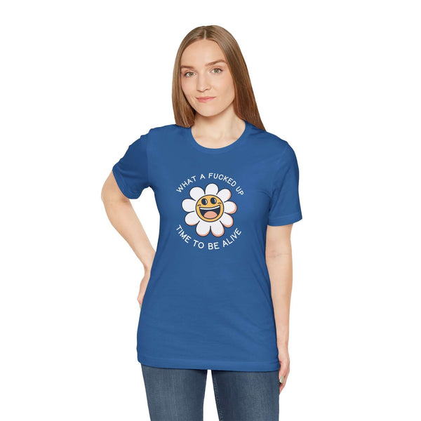 Woman wearing blue premium tee with smiling daisy and 'What a F*cked Up Time to Be Alive' text.