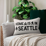 Home is in Seattle Lumbar Accent Pillow on a couch with plants and a cozy blanket.