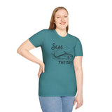 Woman wearing a teal Seas the Day T Shirt with an orca illustration, showcasing coastal charm and ocean vibes.