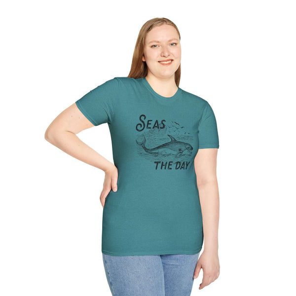 Woman wearing a teal Seas the Day T Shirt with an orca illustration, showcasing coastal charm and ocean vibes.