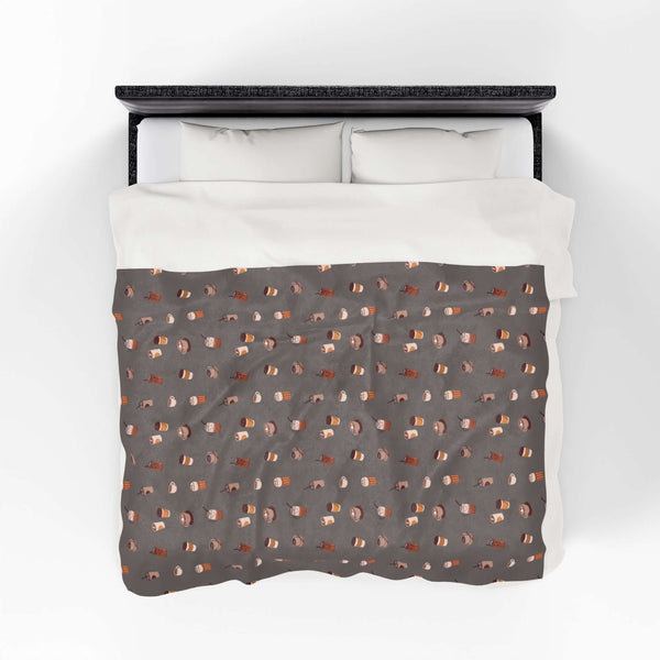 The Daily Grind Coffee Lovers Lightweight Cozy Blanket featuring coffee designs on a warm, cozy fabric.
