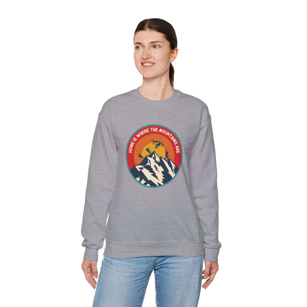 Woman wearing "Home is Where the Mountains Are" sweatshirt showcasing PNW outdoor activities and Bigfoot graphic.