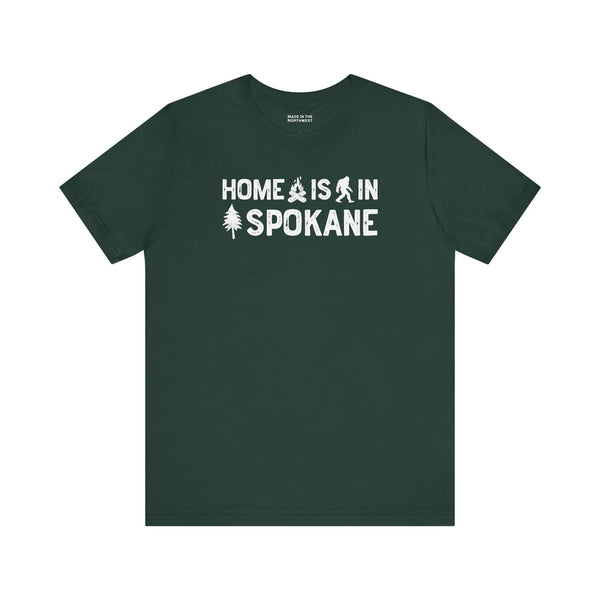 Home Is in Spokane Tee featuring outdoor symbols on a dark green shirt celebrating Spokane pride.