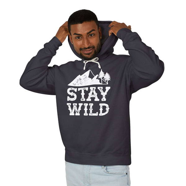 Stay Wild hoodie model wearing a dark sweatshirt with mountain and tree graphic for outdoor enthusiasts.