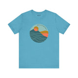 Pacific Peaks Modern Circle Soft Tee with mountain scene design on a blue background, inspired by the Pacific Northwest.