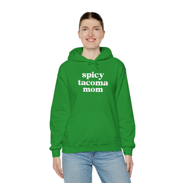 Woman wearing a green Spicy Tacoma Mom hoodie, showcasing casual style and attitude.