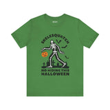 Green Halloween tee featuring Skelesquatch skeleton design with trick-or-treat bucket and graveyard, perfect for spooky celebrations.