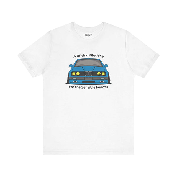 White tee featuring BMW E30 325is graphic with text 'A Driving Machine For the Sensible Fanatic'.