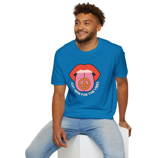 Man wearing blue I'm Just Here for the Vibes Softstyle T-Shirt with colorful lips and peace sign design.