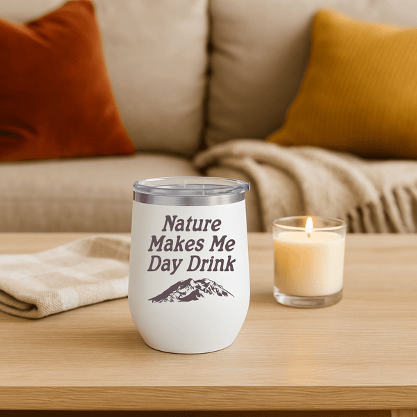 Nature Makes Me Day Drink Camping Wine Tumbler 12 oz on a cozy table with a candle.