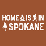 Home Is in Spokane Tee design featuring campfire, Bigfoot, and tree illustrations.